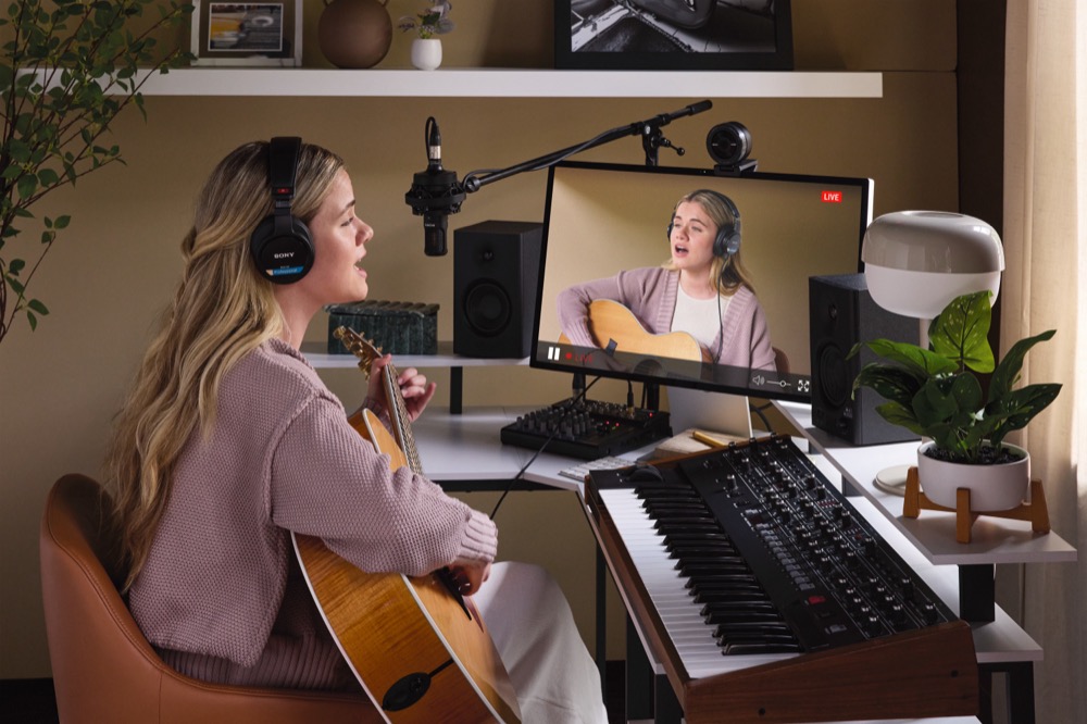 Image of content creator wearing Sony MDR-M1 headphones while doing a livestream playing guitar